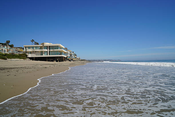 Malibu Beach California view of the oceanfront homes, white sand and rocks.