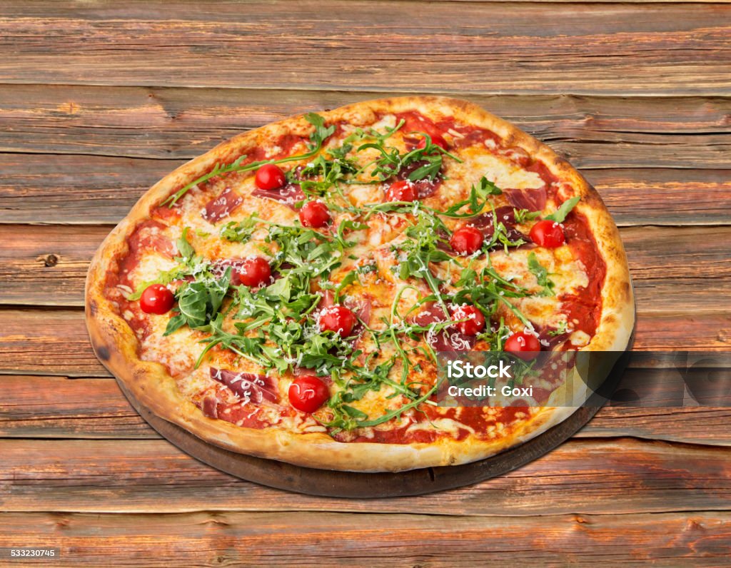 Pizza with rucola, cherry tomato and ham Pizza with rucola ,cherry tomato and ham studio shot 2015 Stock Photo