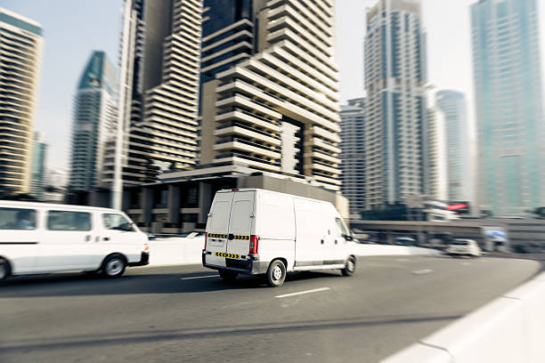 van going fast van going fast, dubai skyscrapers in the background. panning shot with motion blur. car city urban scene commuter stock pictures, royalty-free photos & images