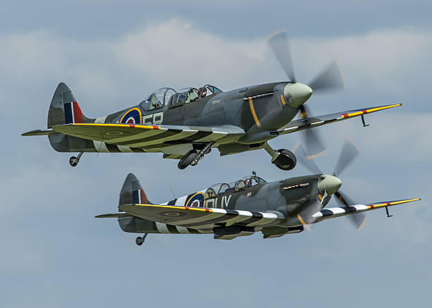Duxford, UK - May 25, 2014: Two rare two-seat training versions of the Spitfire WWII British fighter aircraft in flight over an airfield in Cambridgeshire, England. 