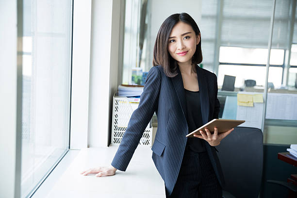 female boss tablet young woman wearing a black suit, using a tablet in her office civil servant stock pictures, royalty-free photos & images