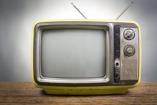 Vintage Television on wood table on gray background