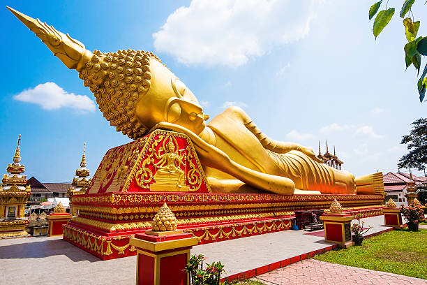 statua di buddha sdraiato a wat pha che luang, vientiane, laos - reclining buddha foto e immagini stock