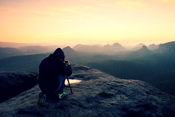 istock Professional photographer with tripod on cliff and work. Dreamy landscape 533240492