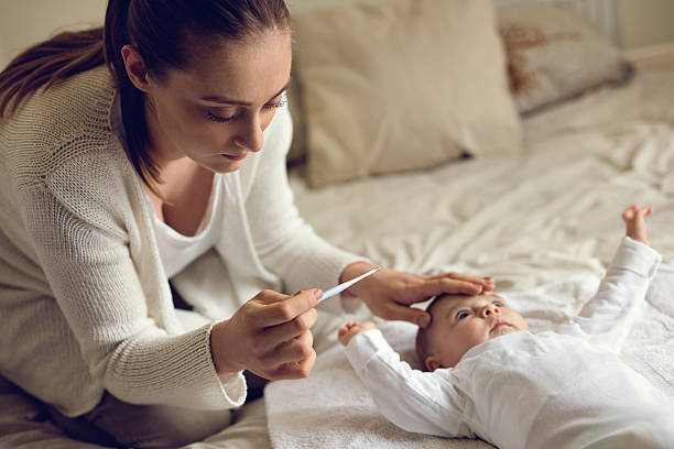 preocupado mãe com bebê de temperatura no quarto). - child fever illness thermometer imagens e fotografias de stock