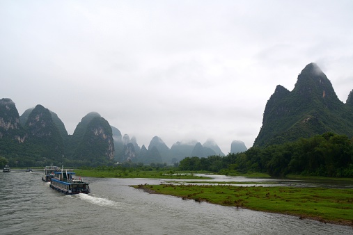 Cruise boats sailing along the beautiful Li river's karst scenery. It ranges 83 kilometers from Guilin to Yangshuo, where the Karst mountain and river sights highlight the famous Li River cruise.