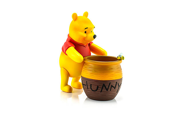 Figure of Winnie the Pooh and hunny pot. Bangkok, Thailand - July 28, 2014 : Figure of Winnie the Pooh and hunny pot. Winine the Pooh is animation from Disney. winnie the pooh photos stock pictures, royalty-free photos & images