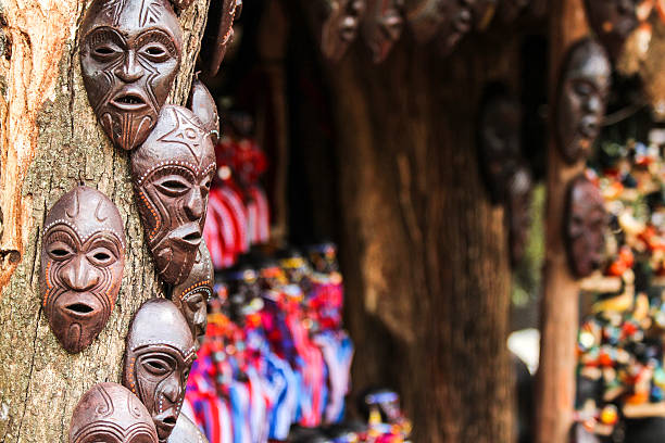 African Masks and Curios African masks and curios fixed onto a tree for sale in Nairobi at a road side curion market  carving craft product stock pictures, royalty-free photos & images