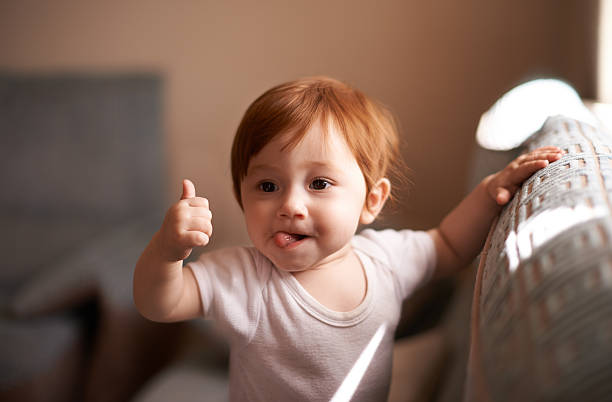 I like that! Shot of a cute baby girl giving the thumbs up little redhead girl stock pictures, royalty-free photos & images
