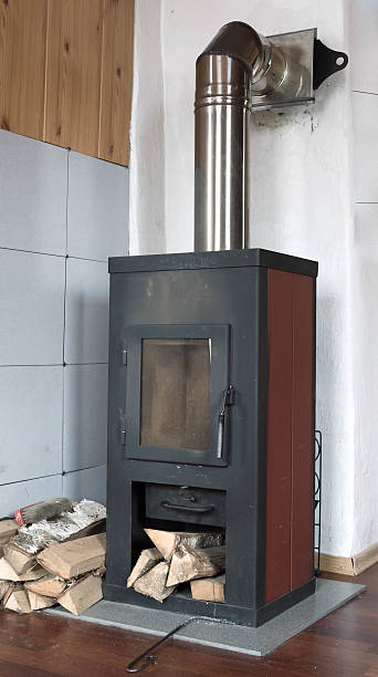 istock rustic metal stove and stacked firewood 533252532