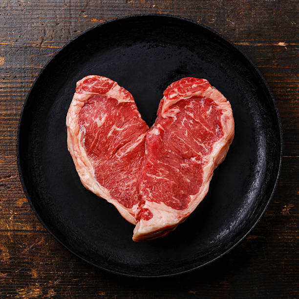 ハート型生肉ステーキをフライパン - meat beef love heart shape ストックフォトと画像