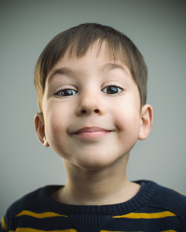 Studio portrait of a caucasian young boy from Spain looking at camera with happy