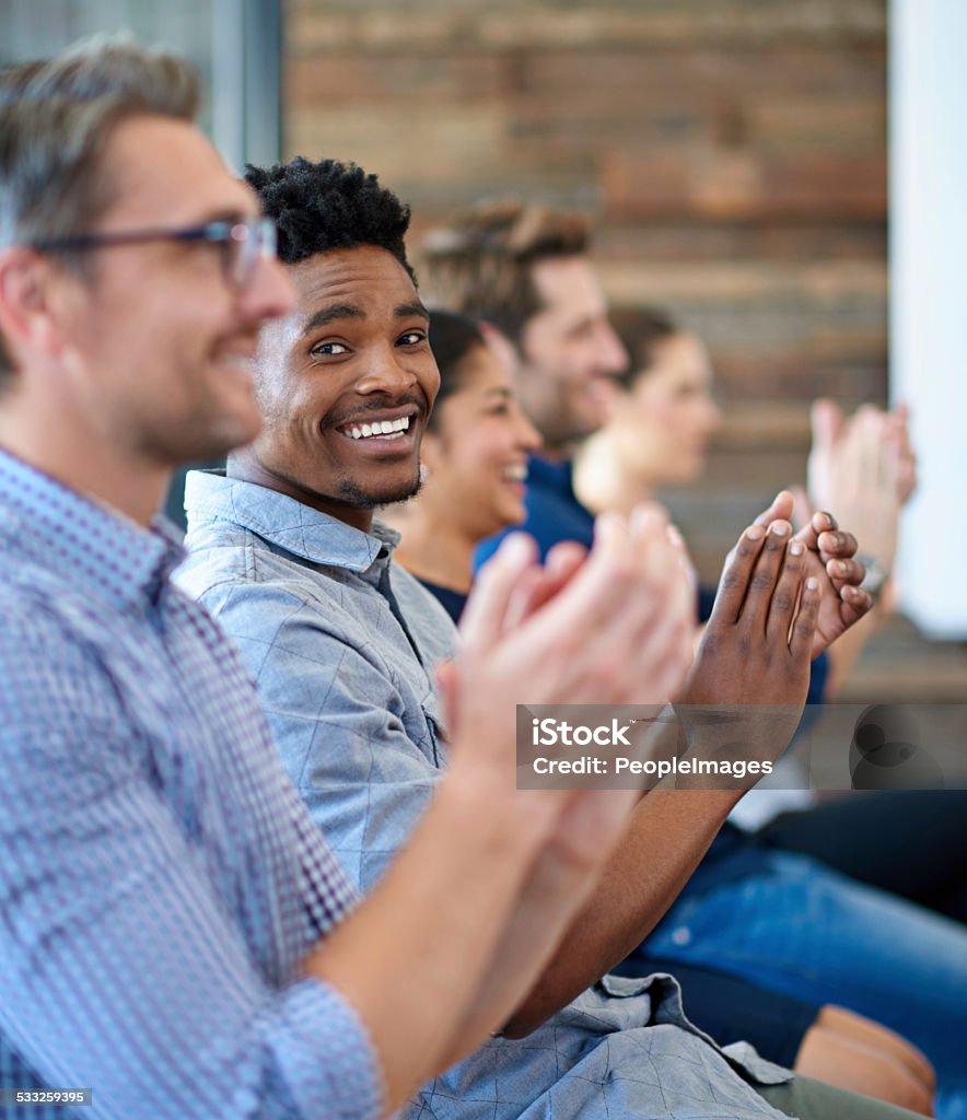 Inspired and motivated Portrait of a handsome man looking at the camera while applauding among colleagues Seminar Stock Photo