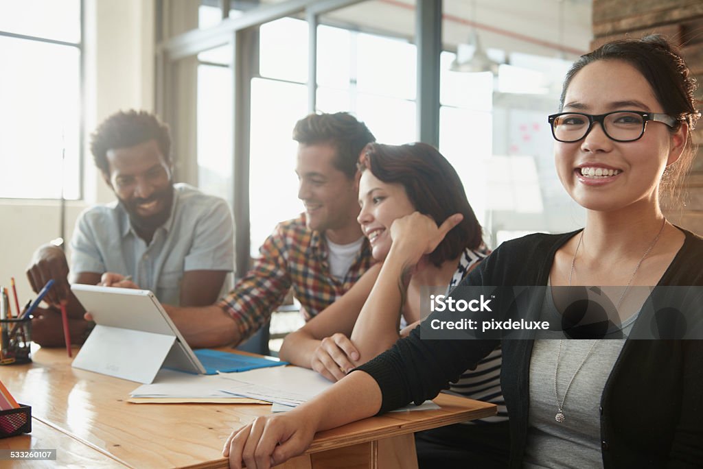 Confident in her career Portrait of an attractive young businesswoman with her colleagues working in the background 2015 Stock Photo