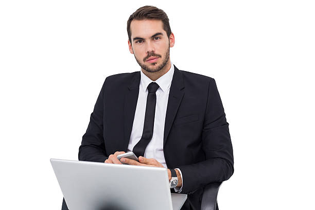 istock Cheerful businessman with laptop using smartphone 533260853