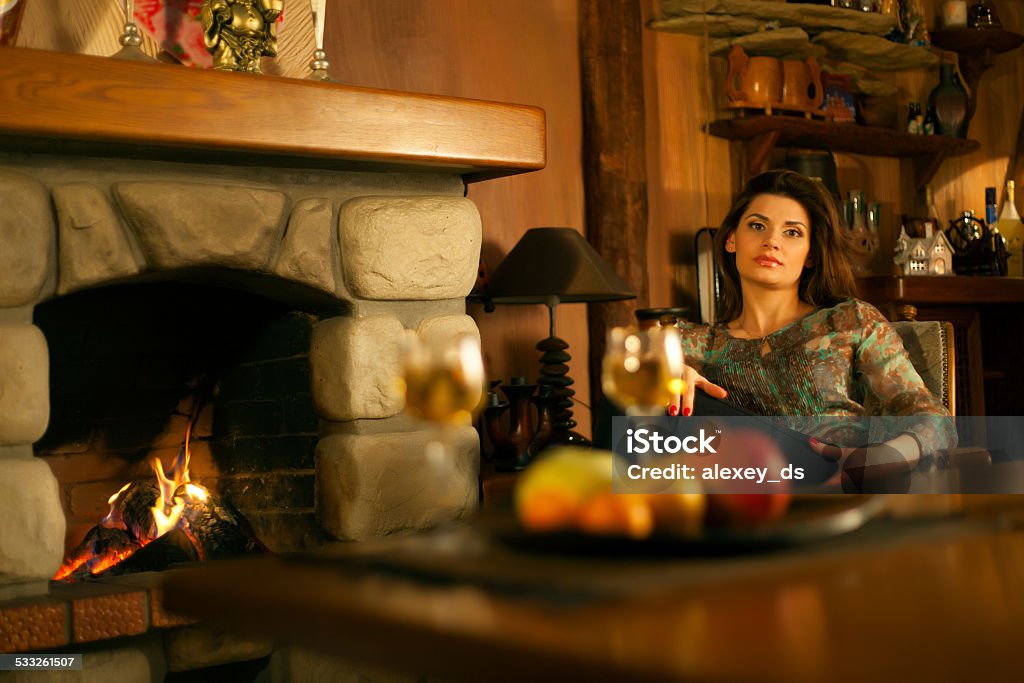Mature attractive pensive woman near the fireplace 2015 Stock Photo