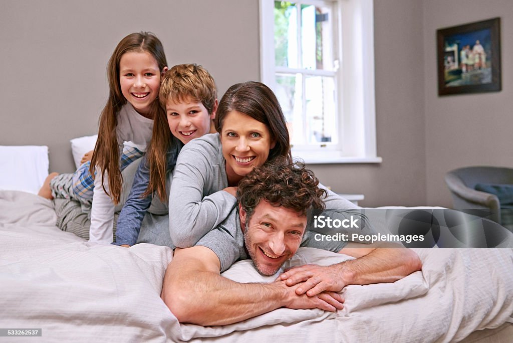 Family time Shot of a happy family of four in the bedroom 2015 Stock Photo