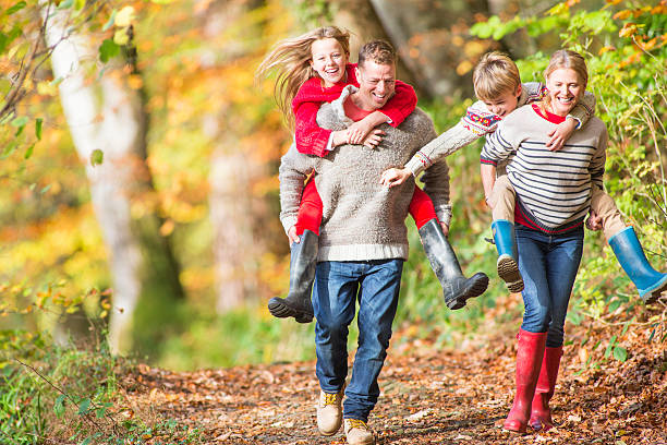 A family enjoys hiking together in nature on a sunny summer day. They walk along a trail, taking in the beautiful surroundings and sharing smiles and laughter.