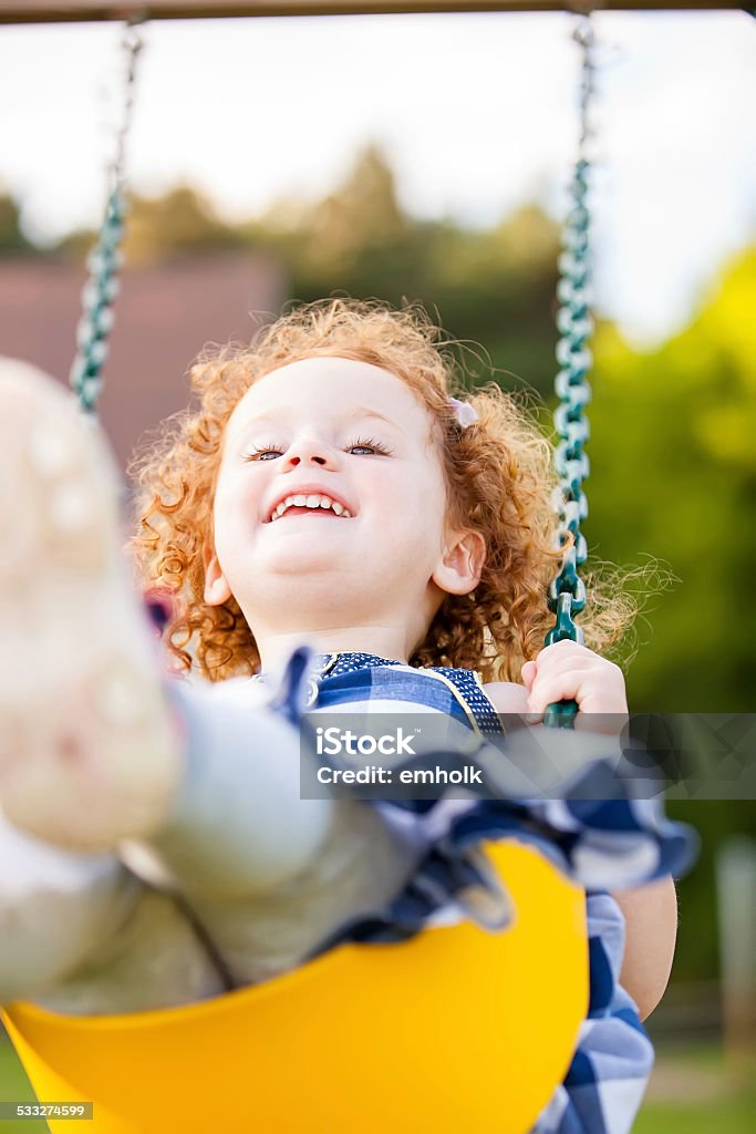 Girl on Yellow Swing Girl having fun on a swing. 2-3 Years Stock Photo