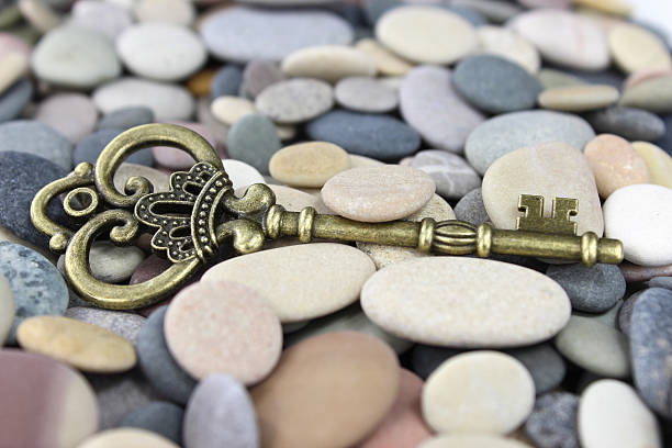 Old Brass key on a pebble beach stock photo