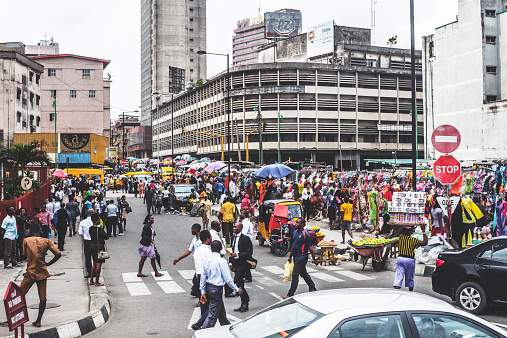 Lagos Island's commercial district, businessmen and market people crossing the street.