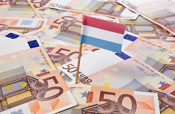 Flag of Luxembourg sticking in european bank notes. 