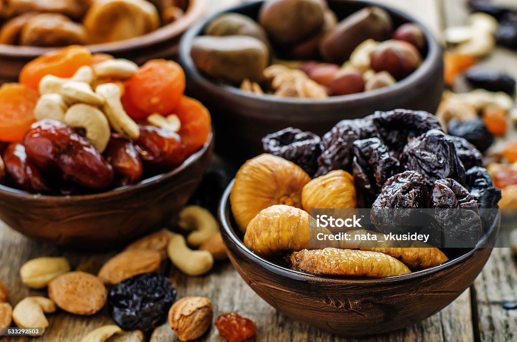 mix of dried fruits and nuts mix of dried fruits and nuts on a dark wood background. tinting. selective focus Fig Stock Photo