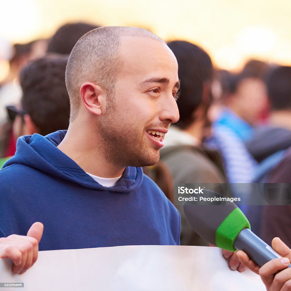 Presenting the case of the people Shot of a protestor being interviewed at a rally 2015 Stock Photo