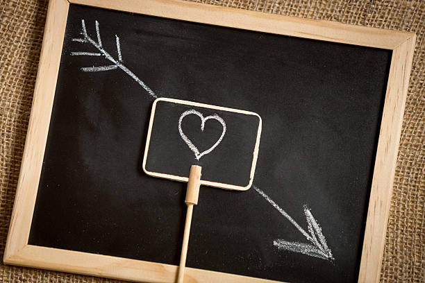 photo of arrow going through heart drawn on blackboard
