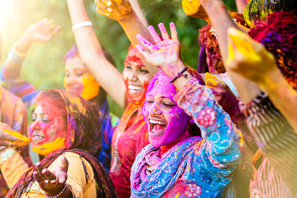 indische frauen werfen bunte holi powder - asian culture dancing women people stock-fotos und bilder