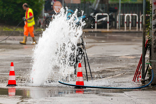 istock road spurt water beside traffic cones and a technician 533329285