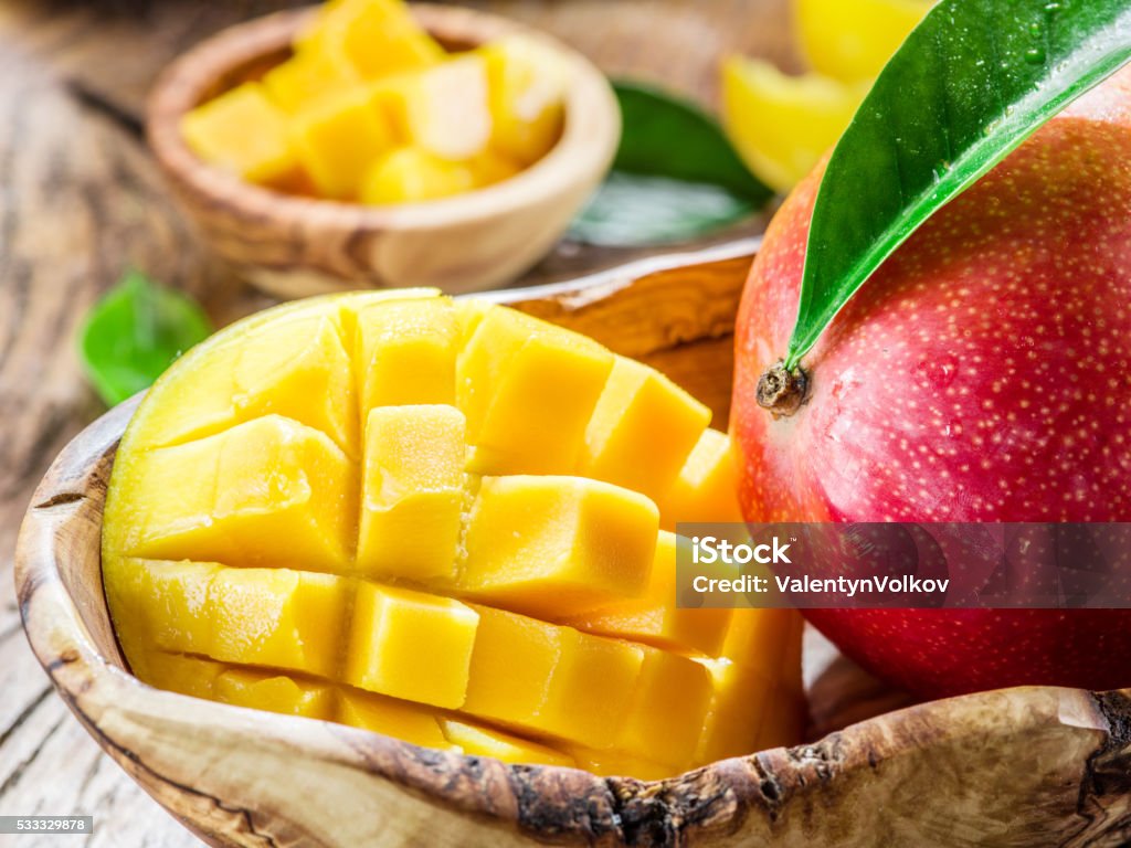 Mango fruit and mango cubes. Mango fruit and mango cubes on the wooden table. Backgrounds Stock Photo