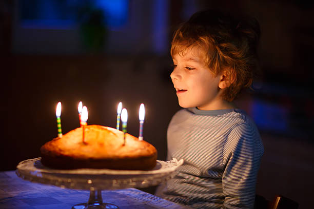 istock Little kid boy blowing candles on birthday cake 533333018