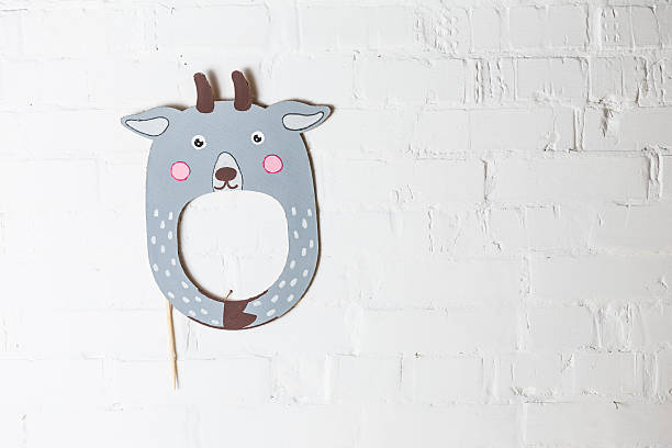 istock Bright cardboard mask on a white brick wall. 533333931