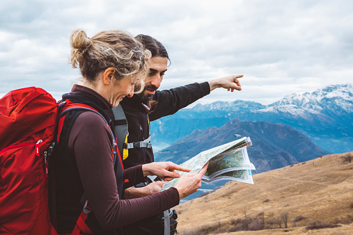 hiking couple with map in mountain.