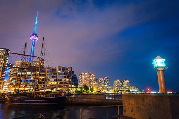 cn tower w toronto, na nabrzeżu apartments oświetlony obok jeziora ontario, kanada - toronto waterfront commercial dock canada zdjęcia i obrazy z banku zdjęć