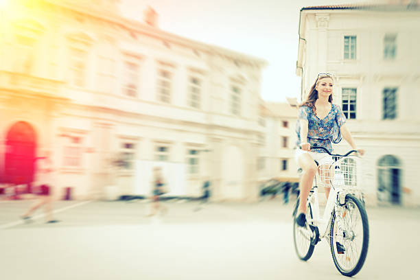 istock young woman cycling through town square 533334841