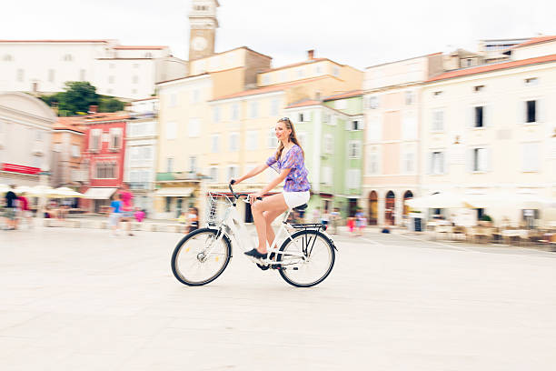 istock young woman cycling through town square 533334843