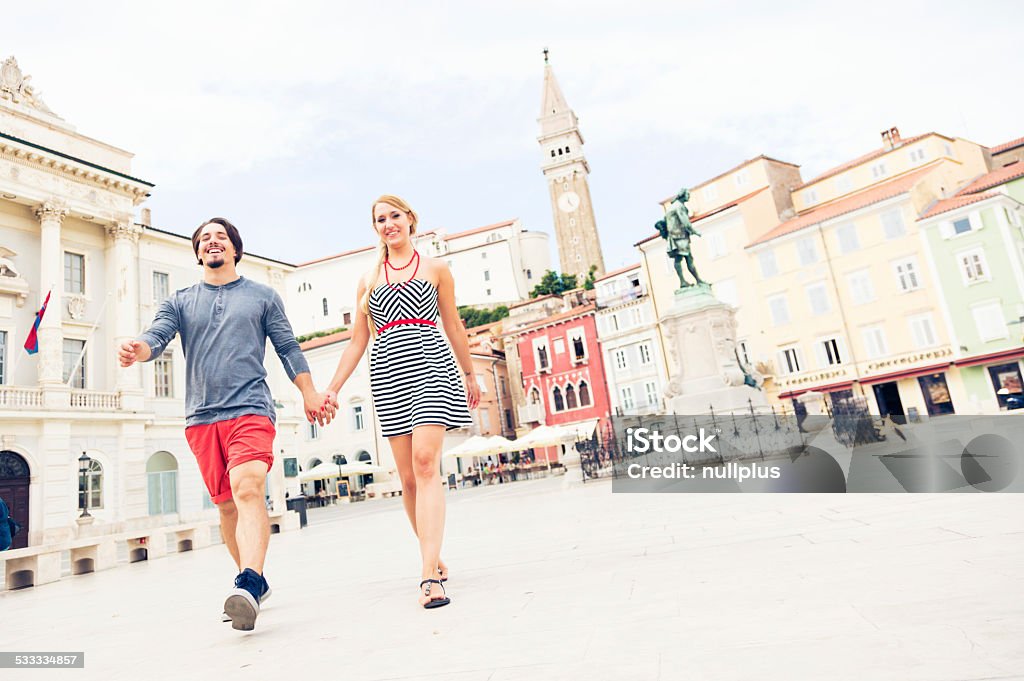 young couple strolling through town square young couple strolling through tartini square, piran, slovenia. Piran Stock Photo