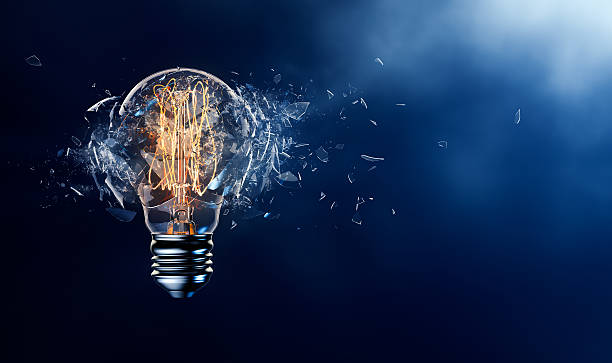 Exploding Light Bulb Exploding light bulb on a blue background breaking stock pictures, royalty-free photos & images