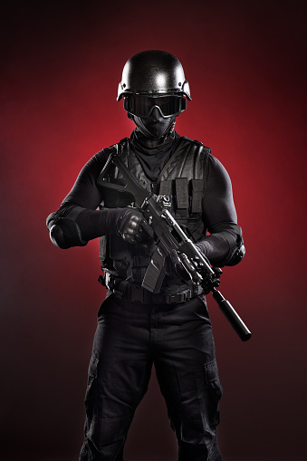 Studio shot of modern military soldier holding a rifle.