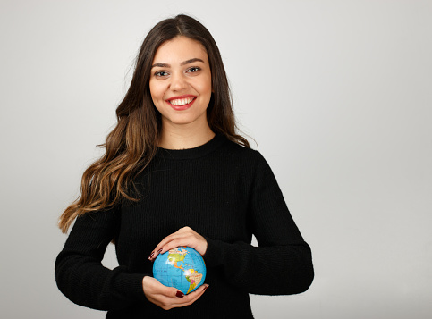 Young woman holding world in hands.