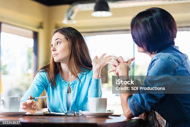 Annoyed Teen Girl Talking To Mother In Coffee Shop Stock Photo - Download Image Now - Rudeness, Arguing, Friendship