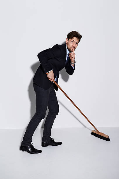 istock Businessman sweeping up with finger on lips, portrait 533343736