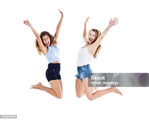 Jumping For Joy Two Young Beauties Leap Up Laughing Stock Photo - Download Image Now