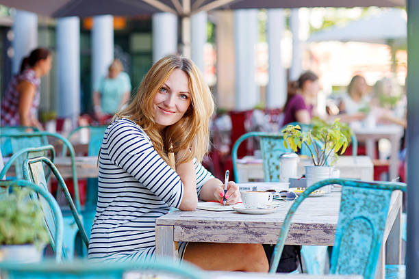 istock Woman drinking coffee and writing notes in cafe 533344048