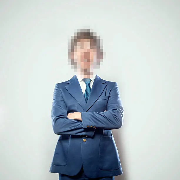 A portrait of a business man from the waist up, whose face has been rendered unrecognizable by being pixelated.  A conceptual representation of individual identity protection.  Square crop with copy space on a a clean off-white background.