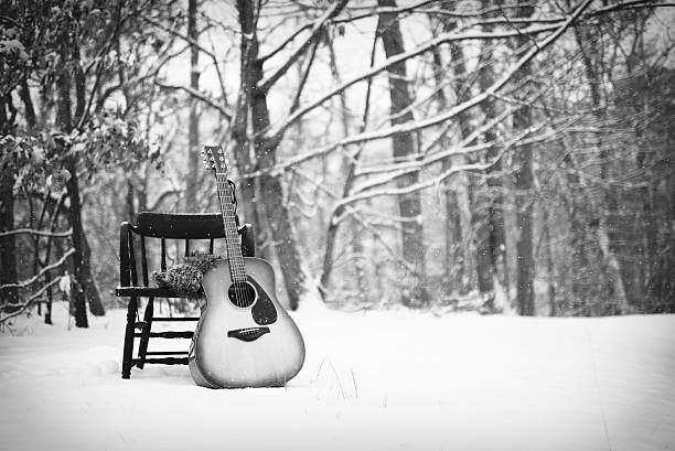 Guitar Against a Chair in Snow Black and White stock photo
