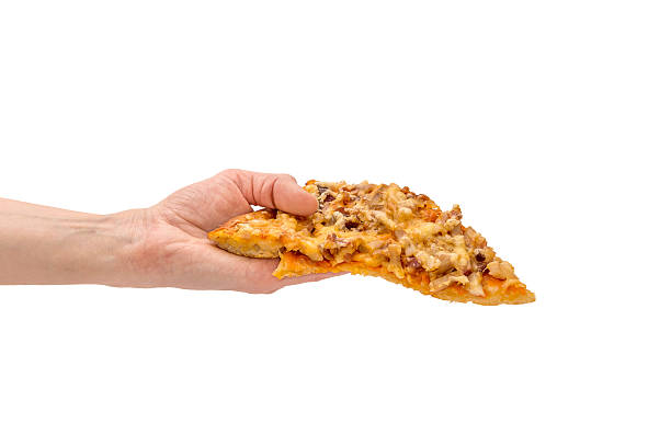 Piece of pizza in hand isolated on white stock photo