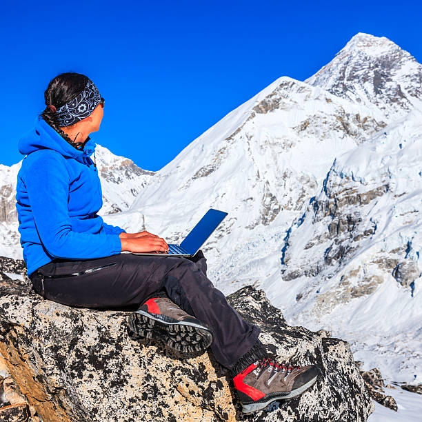 istock Woman is using laptop in Himalayas, Mount Everest on background 533344981
